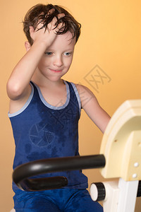 孩子在固定自行车上接受训练引领健康的生活方式男孩发展肌肉又累图片