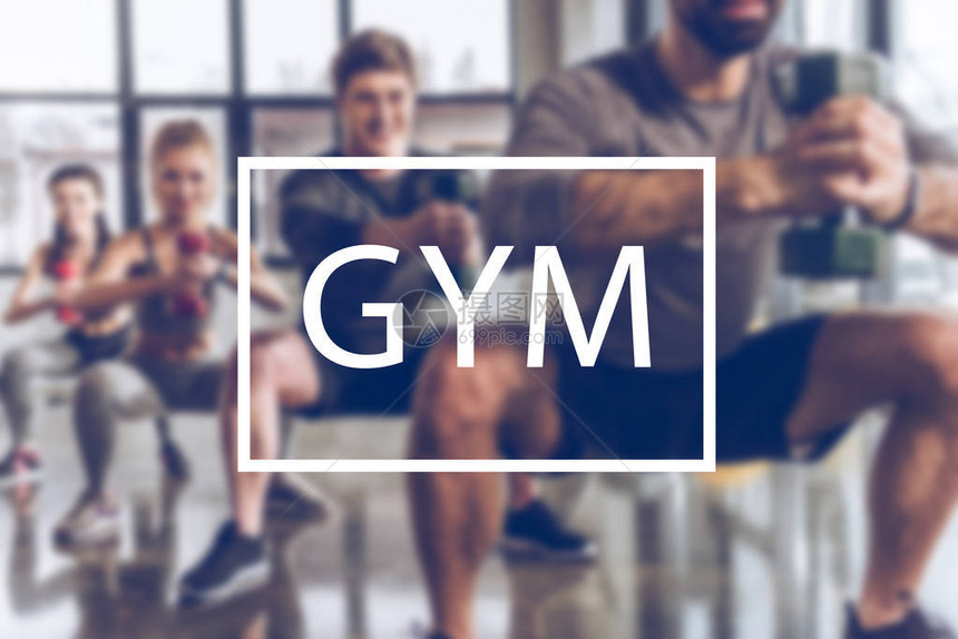 一群身穿运动服带着哑铃在健身房锻炼健身房题词的运动图片