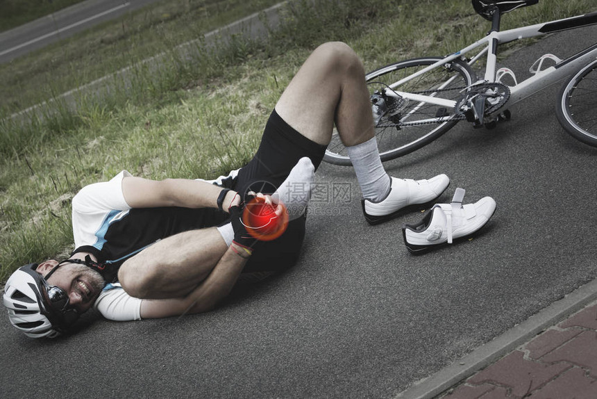 自行车事故骑自行车的人抱着他的脚踝图片