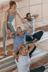 在健身工作室的瑜伽垫子上坐着的老年人接图片