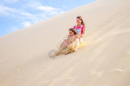 两个快乐的女孩在沙背景图片