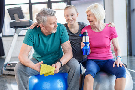 坐在健身球上微笑的老年夫妇和在健身班图片