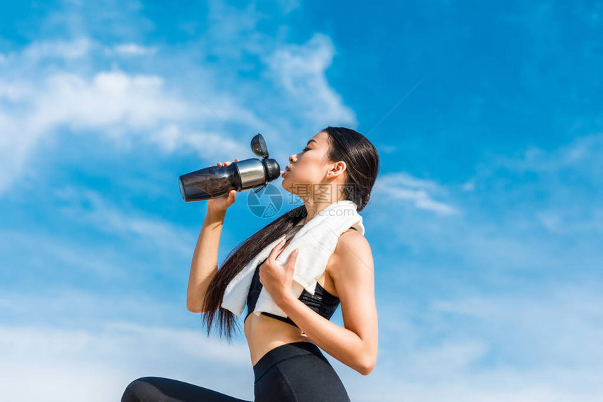 女运动家疲累的女运动员从运动瓶中饮水对图片