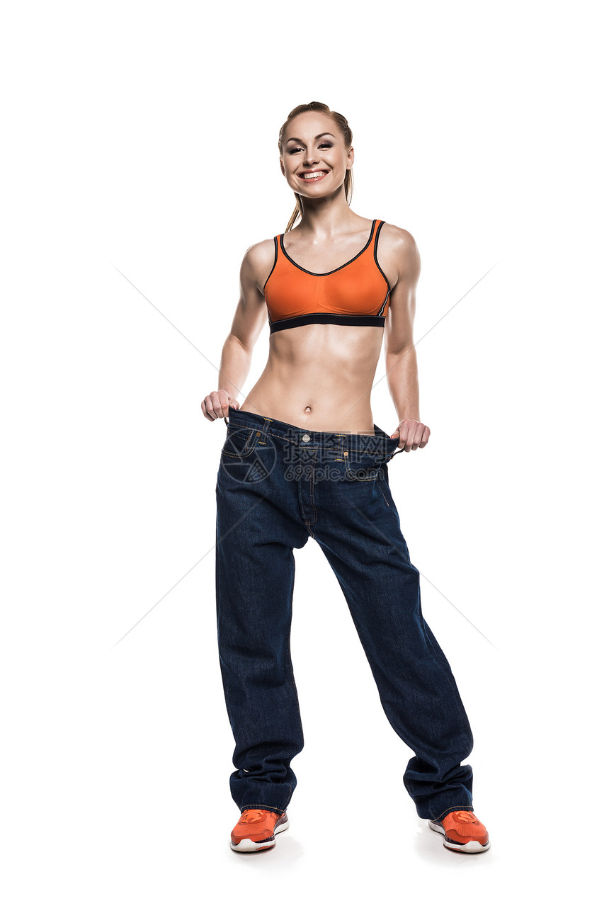 身穿超大牛仔裤的快乐运动女运动员展示图片