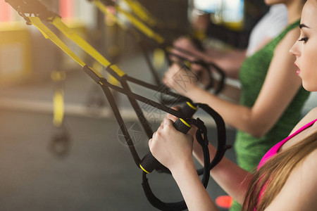 在健身房进行悬挂训练的面目全非的女人用弹力绳复制空间特写进行拉伸运图片