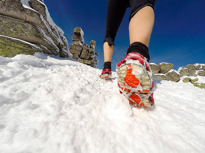 在冬季小径雪和白山上奔跑的女人图片