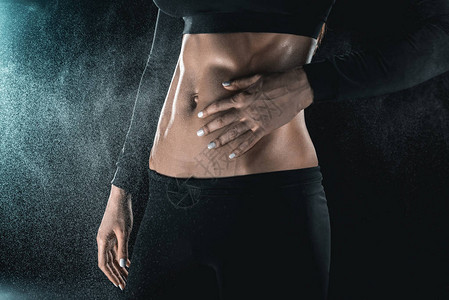 女人的肌肉发达的身体被黑色隔离运动概念图片