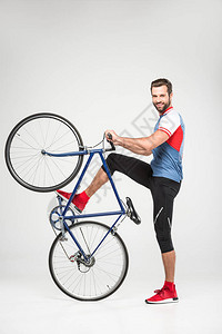 英俊的微笑运动员与自行车合影图片