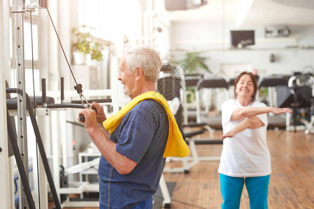 在健身中心锻炼的老人侧视高级加索男子在健身馆的肩部训练用毛巾适合所有图片