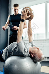 高级运动员在健身场接受健身球和医学球健身训练图片