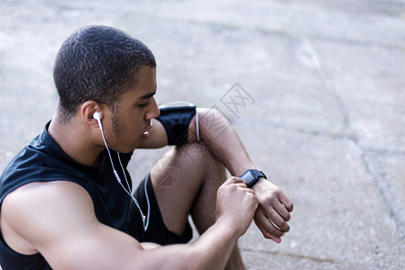 使用智能观察用耳听器收听的非洲青年运动员图片