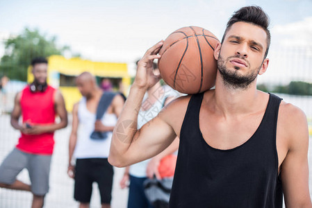 英俊篮球运动员的肖像肩上打球图片