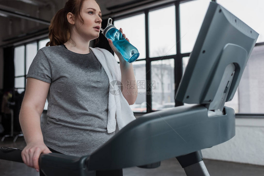 在健身运动场跑步时喝水瓶喝水的c图片