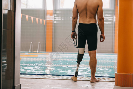 站在室内游泳池前的假腿运动员被射中图片