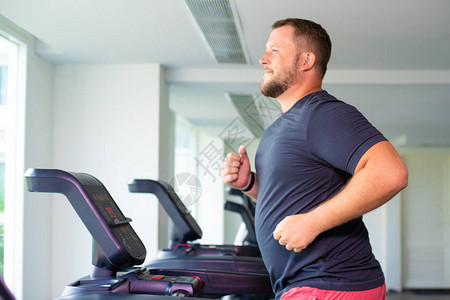 男在健身房的跑步机上奔跑体重减肥图片