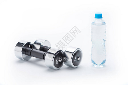 金属哑铃和瓶子上白色孤立的水饮用水设备运动和图片