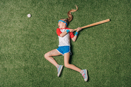 在草地上打棒球的小女孩运动儿童的概念图片