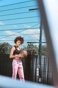 身穿运动胸罩和粉红内衣手握篮球的年轻非高清图片
