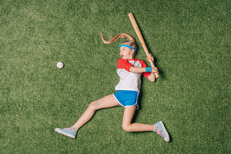 在草地上打棒球的小女孩运动儿童的概念图片