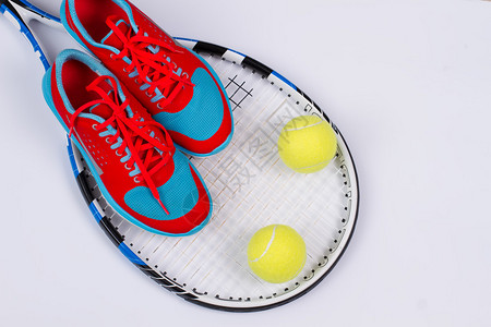 明亮的女式跑鞋带网球和白色背景的网球拍图片