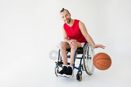 坐在轮椅打篮球微笑孤立在灰色上的残背景图片