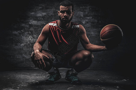 一个黑人篮球运动员的全身肖像坐在地板图片
