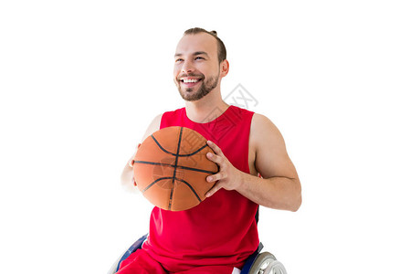 快乐的年轻运动员坐在轮椅上拿着篮球背景图片