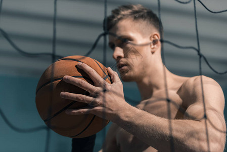 运动型男子手里拿着篮球的侧视图图片