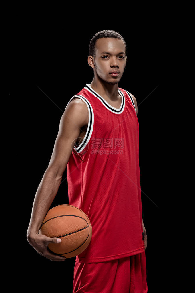 年轻自信的篮球选手站在球图片