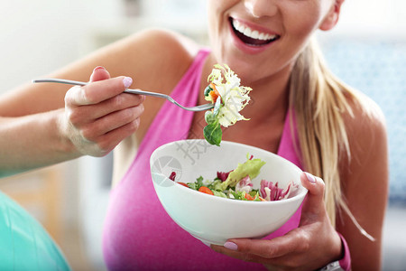 锻炼后吃健康沙拉的年轻女背景图片
