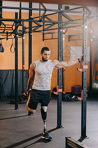 健壮的年轻运动员有人工腿在健身房体操图片