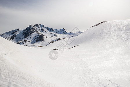 登山者在雪坡上滑雪游览上山图片