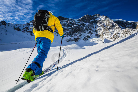 登山者偏远地区滑雪沿着雪脊行走高清图片