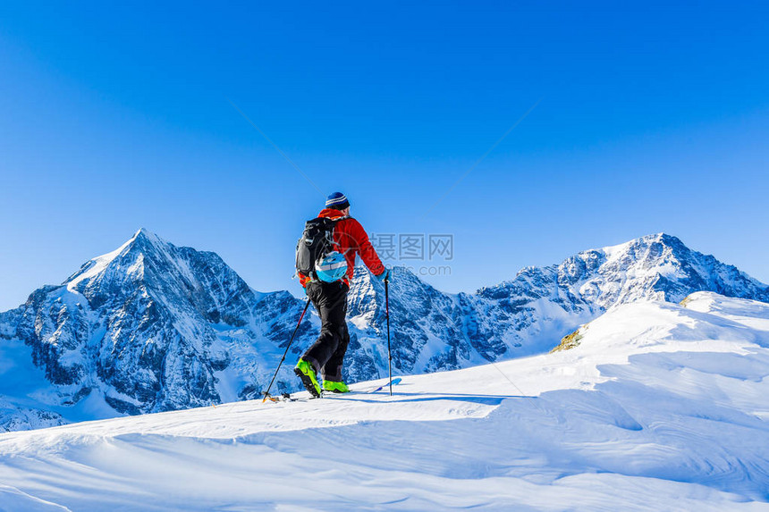 登山者偏远地区滑雪沿着雪脊行走图片