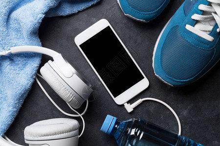 健身概念背景与运动鞋耳机智能手机水瓶和毛巾带复制图片