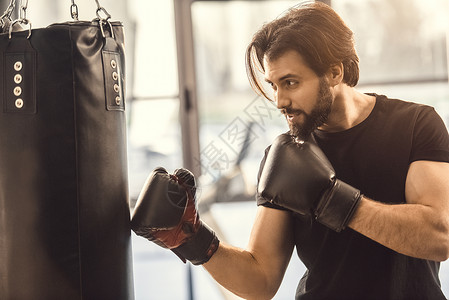 年轻运动员在拳击手套运动的一面图片