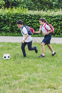 在公园草地上一起踢足球的活跃图片