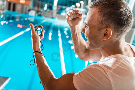 兴奋的游泳教练手表站立在图片