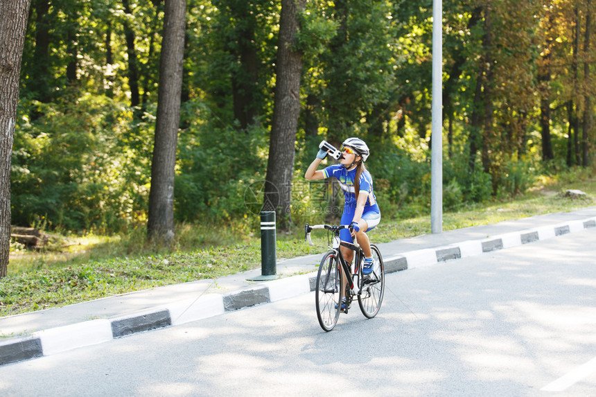 女运动员骑自行车的人在比赛中从瓶子里喝水骑赛车休息图片