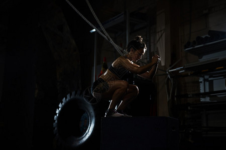强壮的女人在健身房跳箱训练图片