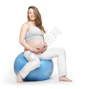 孕妇在蓝球上锻炼产前保健概念图片