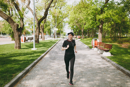 年轻的微笑运动黑发女孩穿着黑色制服图片