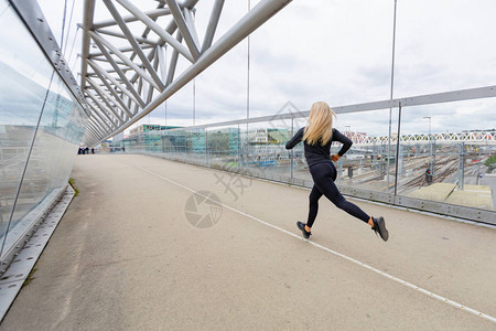 女在现代城市快速跑步时夏图片