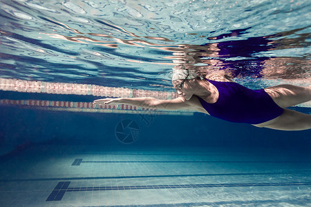 年轻女游泳女运动员在游泳池中锻背景图片