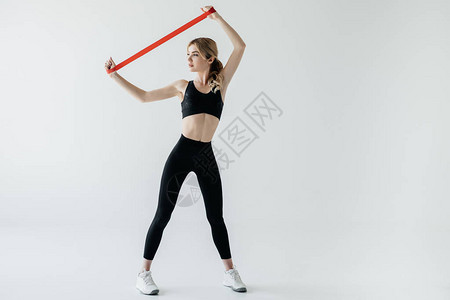 年轻运动女青年运动妇女用胶带锻炼在图片
