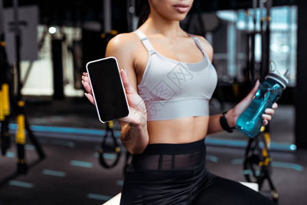 党建带妇建在健身房拥有智能手机的运动妇背景