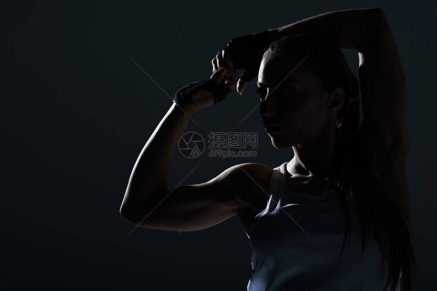 在灰色地带被隔离的强壮运动女运动员显示肌肉图片