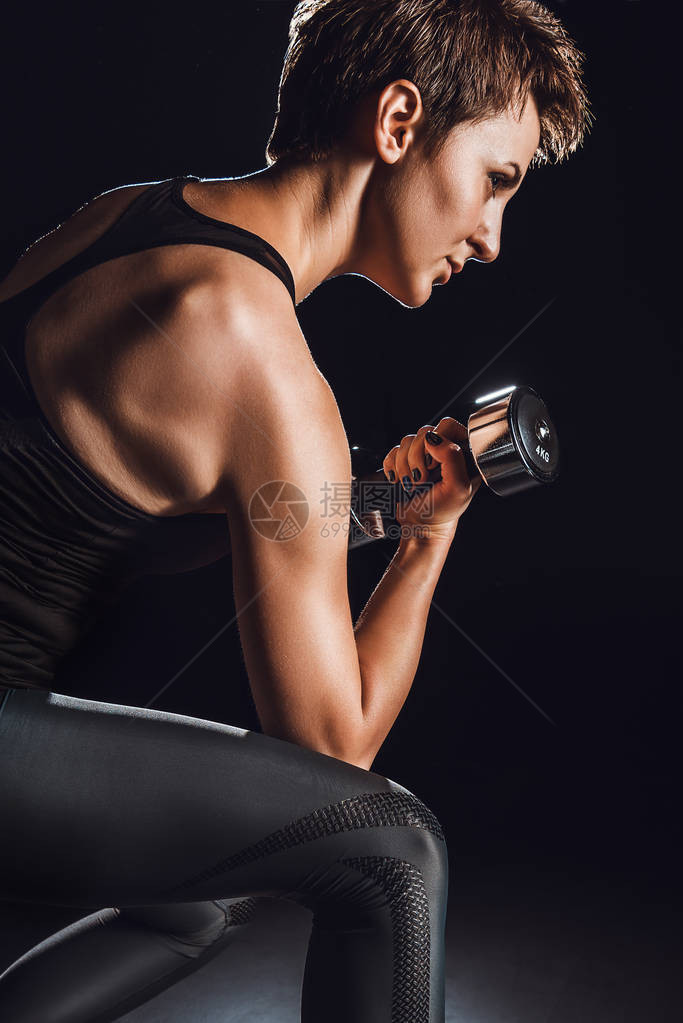 女运动员在健身黑色背景上用哑图片