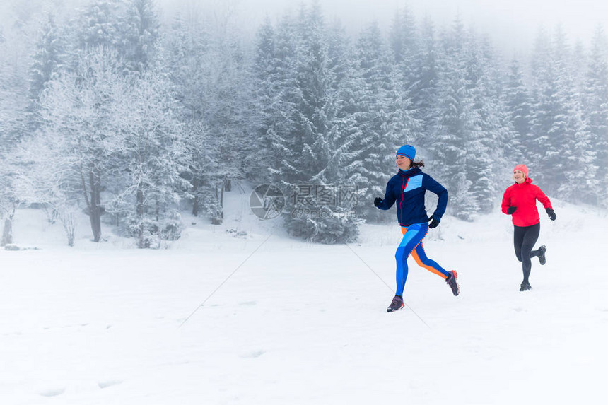 女孩们在冬天的山上一起在雪地上奔跑健身的灵感和动力两个女伙伴在山上跑步图片