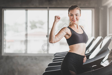 健康的caucasians女人在健身房使用跑步机时露图片